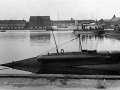 DRYADENs agterstævn med de to torpedorør. Ved Ubådsbroerne ses to andre undervandsbåde og i Flådens Leje ses kongeskibet DANNEBROG.