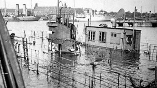 HAVFRUEN i den sænkede dok. Her ses også tydeligt dokkens maskinhus, som Tuxen måtte bryde ind i for at få sænket dokken. (Orlogsmuseet)