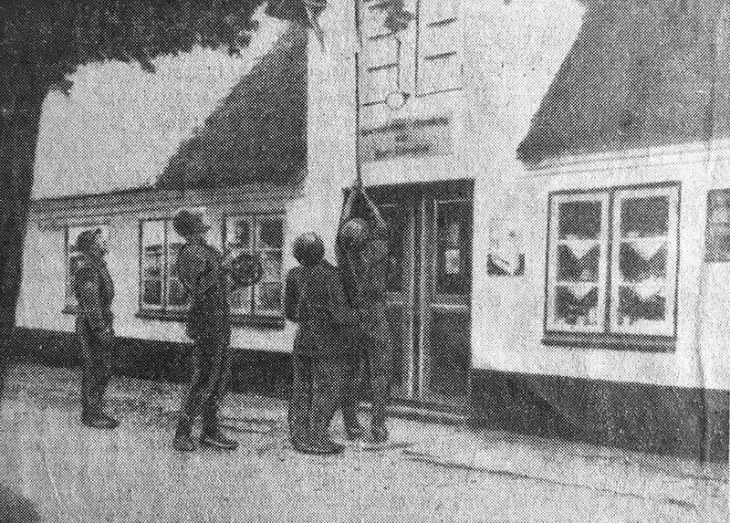 Danske soldater lægger felttelefonledning over købmandens tag i Syd-Smedeby. Foto fra Flensborg Avis 17. september 1952.